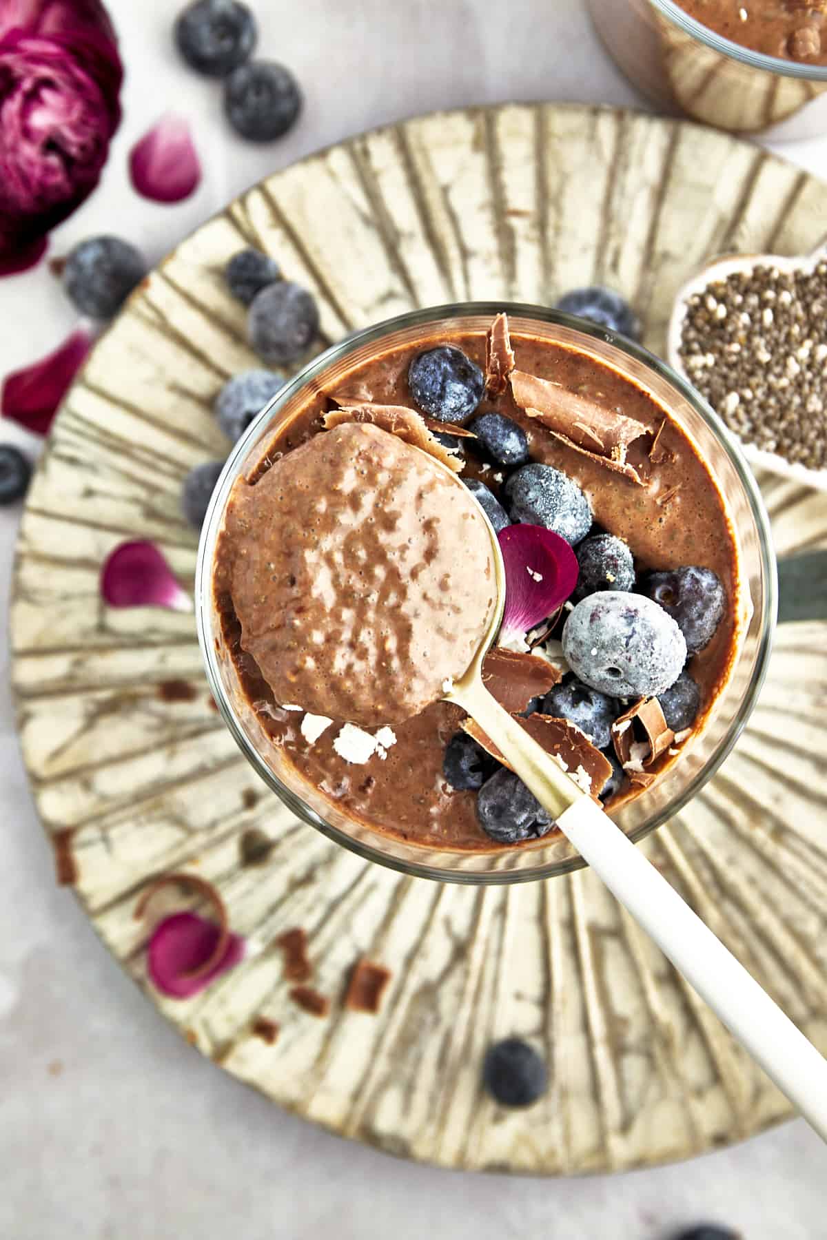 Overhead image of a spoon lifting a bite of chocolate chia pudding from a jar. 