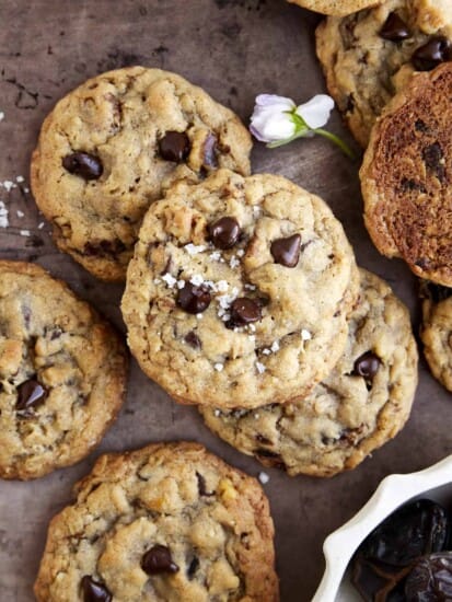 Overhead image of baked Date Cookies with chocolate chips and walnuts topped with sea salt.
