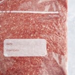 A bag of flattened raw ground beef.