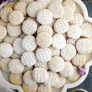 A platter of plain kahk cookies dusted with powdered sugar.