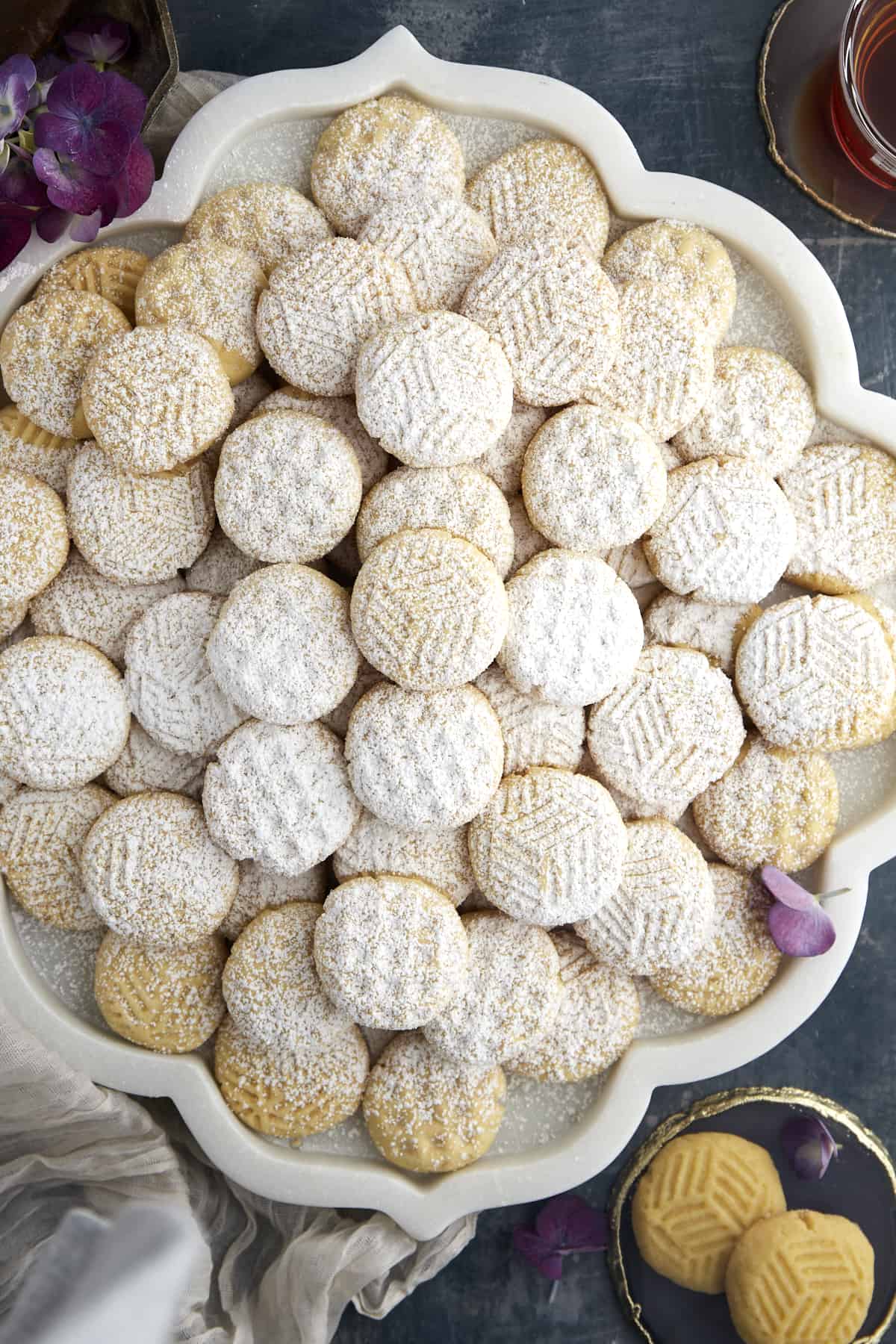 A platter of plain kahk cookies dusted with powdered sugar.