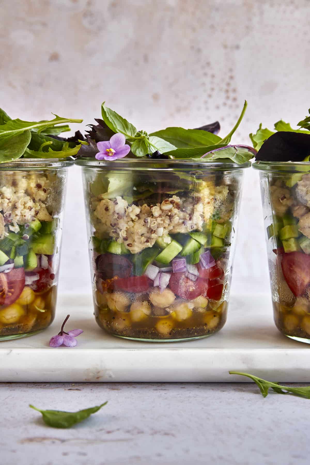 Three Mediterranean quinoa salad in a jar portions. 