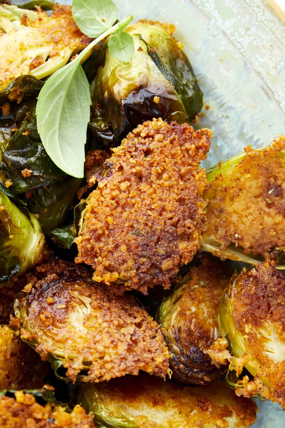 Close up image of a Brussels sprout coated with Parmesan. 