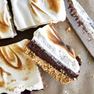 Sliced s'mores bars with a graham cracker layer, chocolate ganache, and a meringue topping.