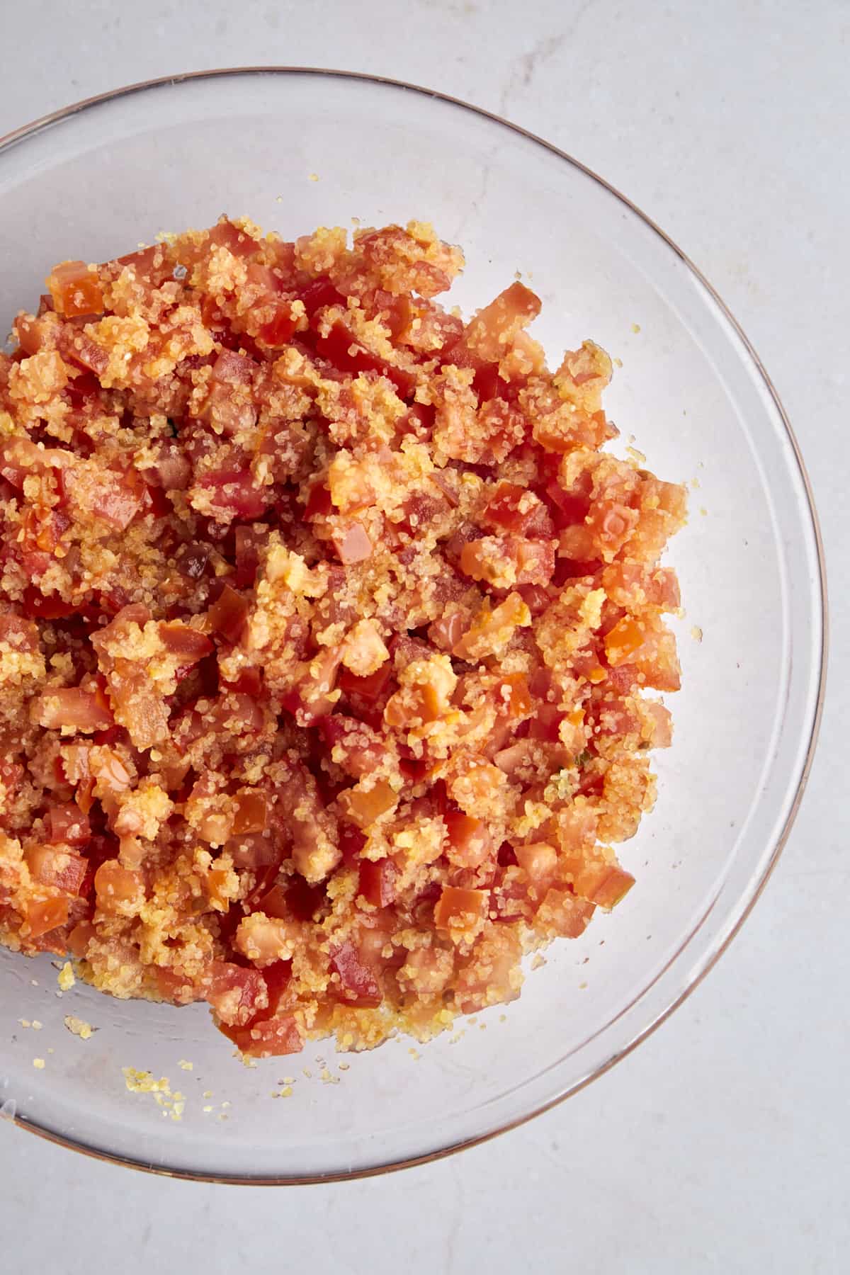A bowl of bulgur wheat with chopped tomatoes. 