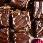 Squares of chocolate zucchini cake topped with chocolate frosting.