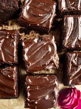Squares of chocolate zucchini cake topped with chocolate frosting.