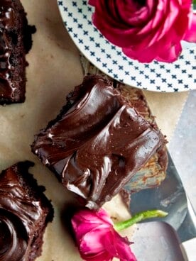 A square of chocolate zucchini cake topped with chocolate frosting.