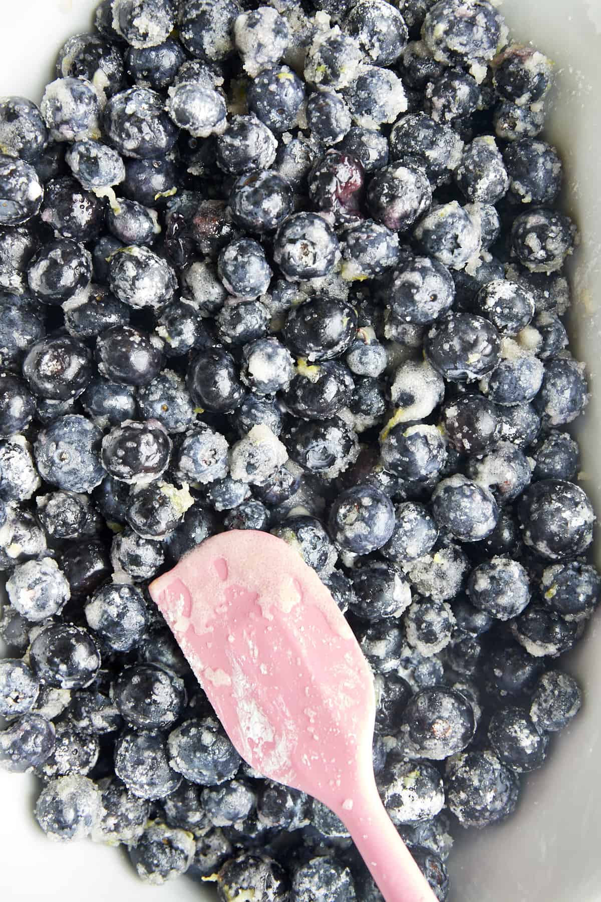 Blueberries, sugar, lemon juice, lemon zest, and cornstarch being mixed. 