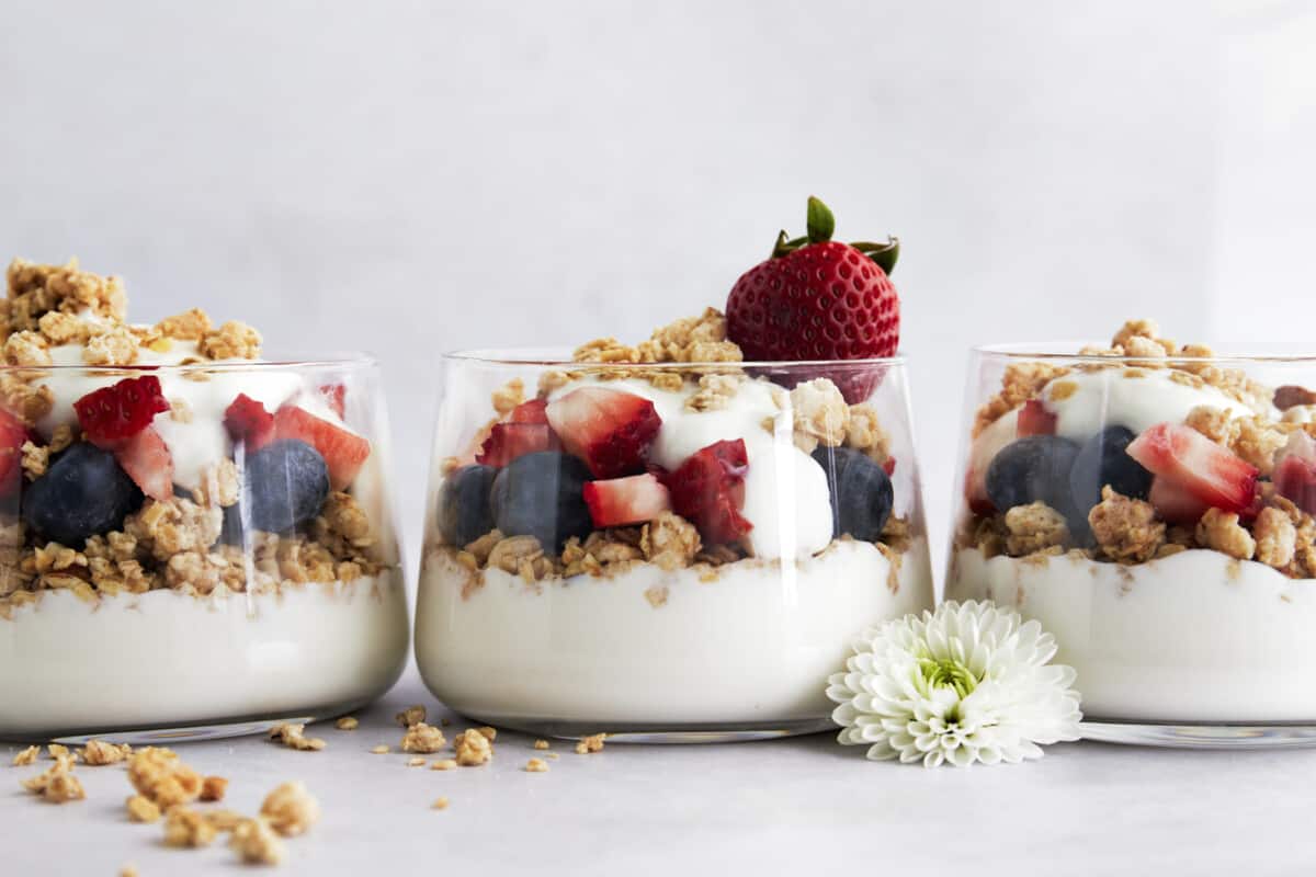 Three jars full of fruit and yogurt parfaits. 