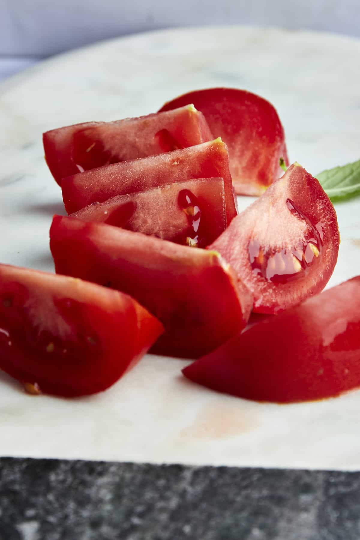 Fresh tomato wedges on a cutting board. 