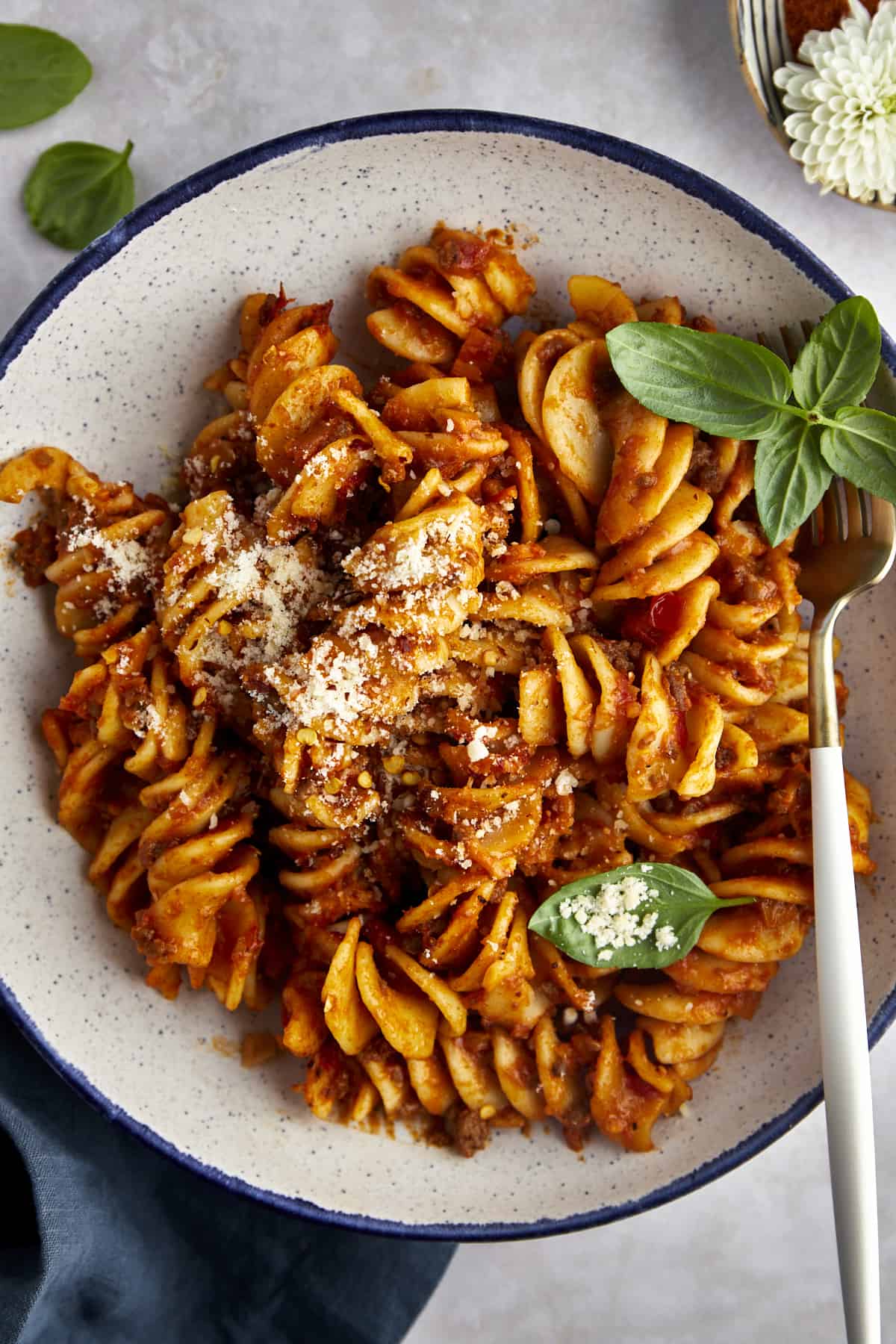 Overhead image of a bowl of taco pasta topped with Parmesan cheese. 