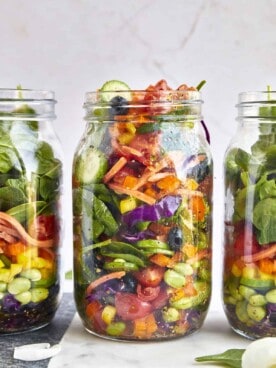 Three mason jars full of rainbow salad.