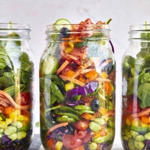 Three mason jars full of rainbow salad.