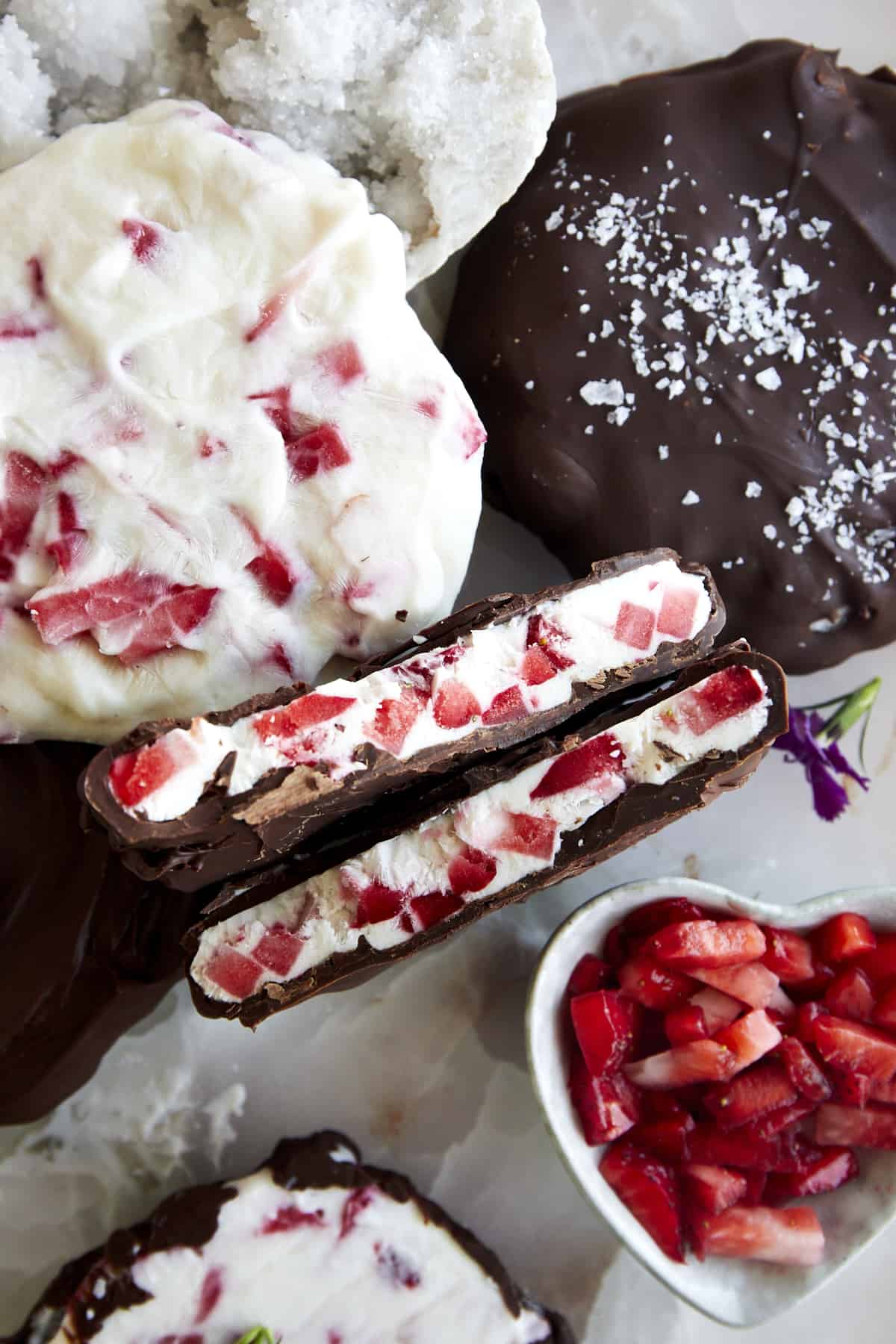 A chocolate strawberry yogurt cluster split in half showing the yogurt center. 