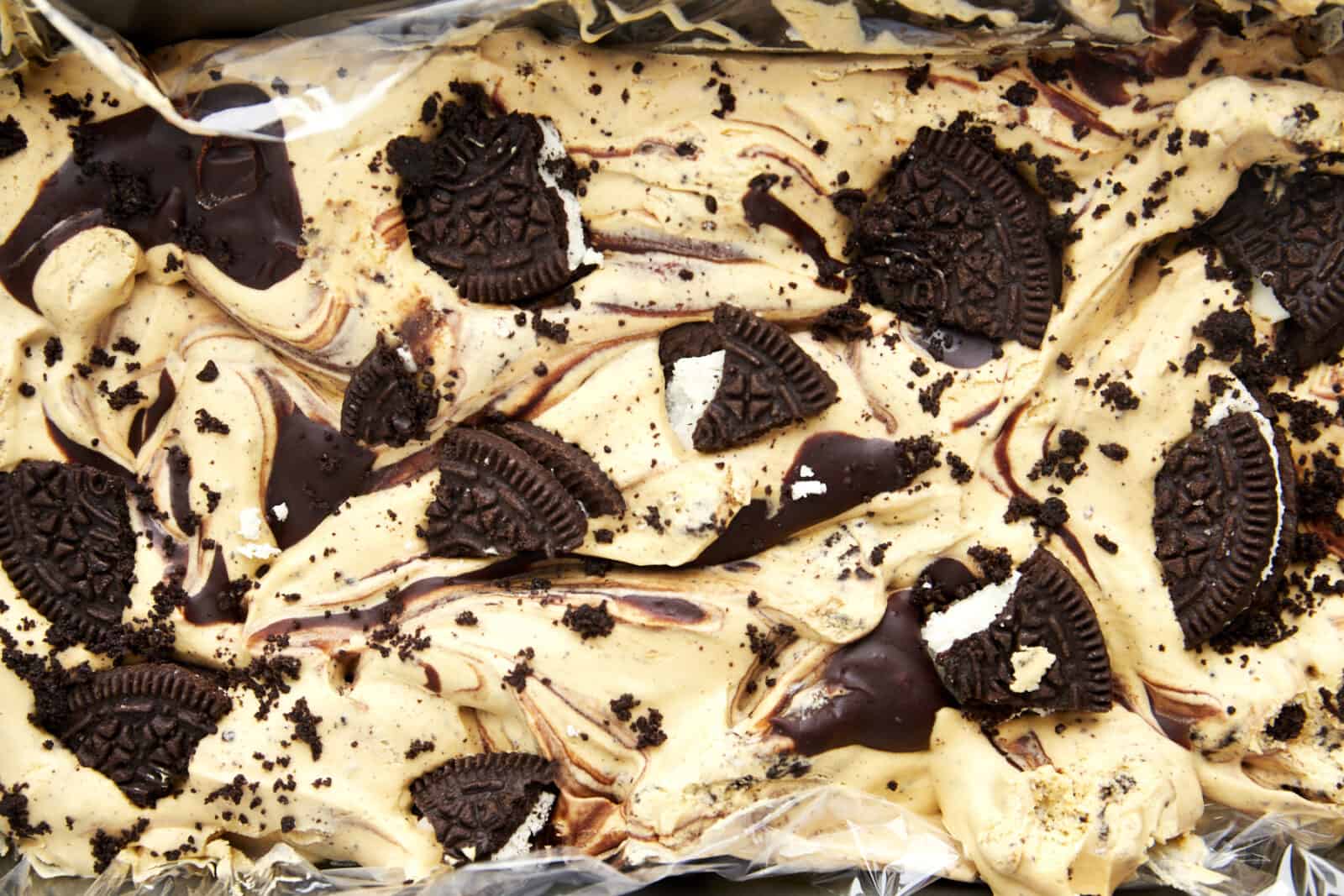 overhead image of mocha Oreo no churn ice cream topped with Oreo chunks in a loaf pan. 