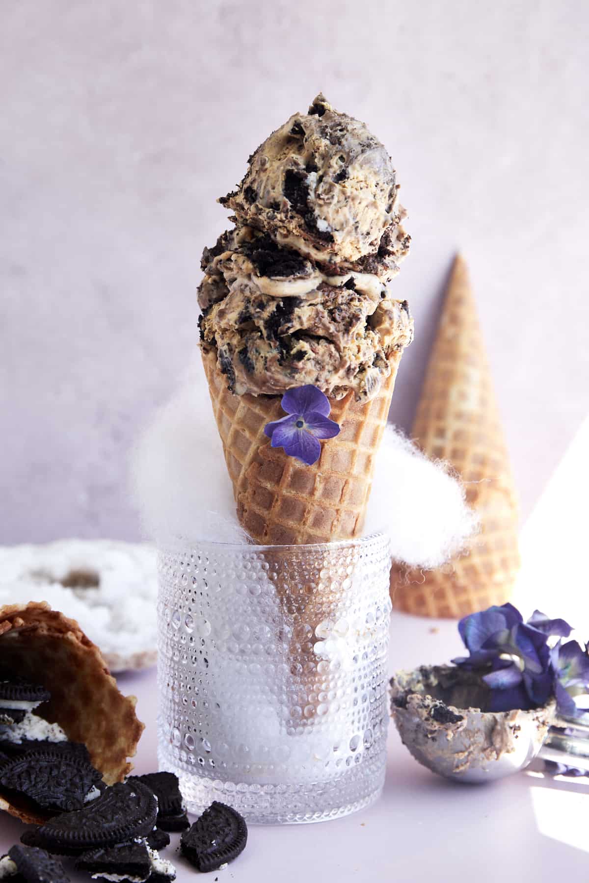 A glass bowl holding a waffle cone with two scoops of mocha Oreo no churn ice cream. 
