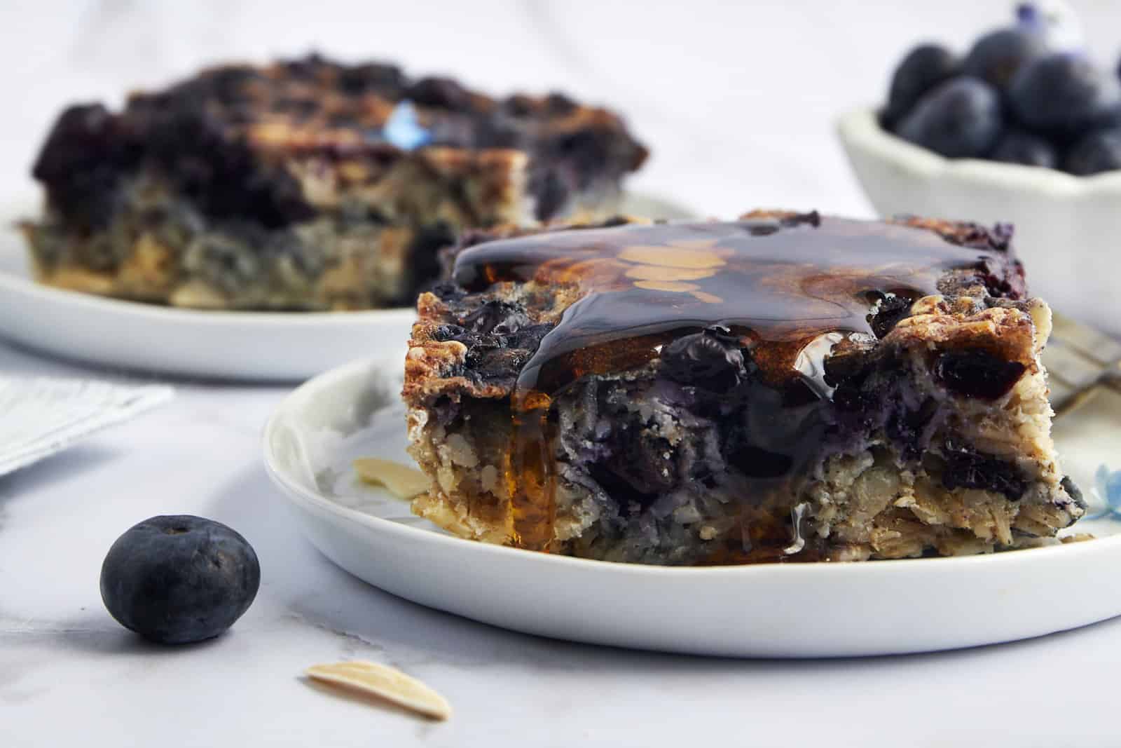 Two plates full of slabs of blueberry baked oatmeal.