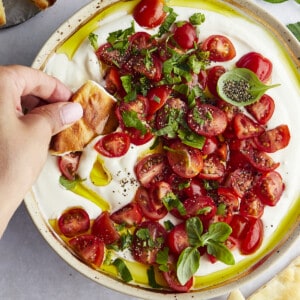 Marinated tomatoes and whipped feta dip with pita bread dipped in.