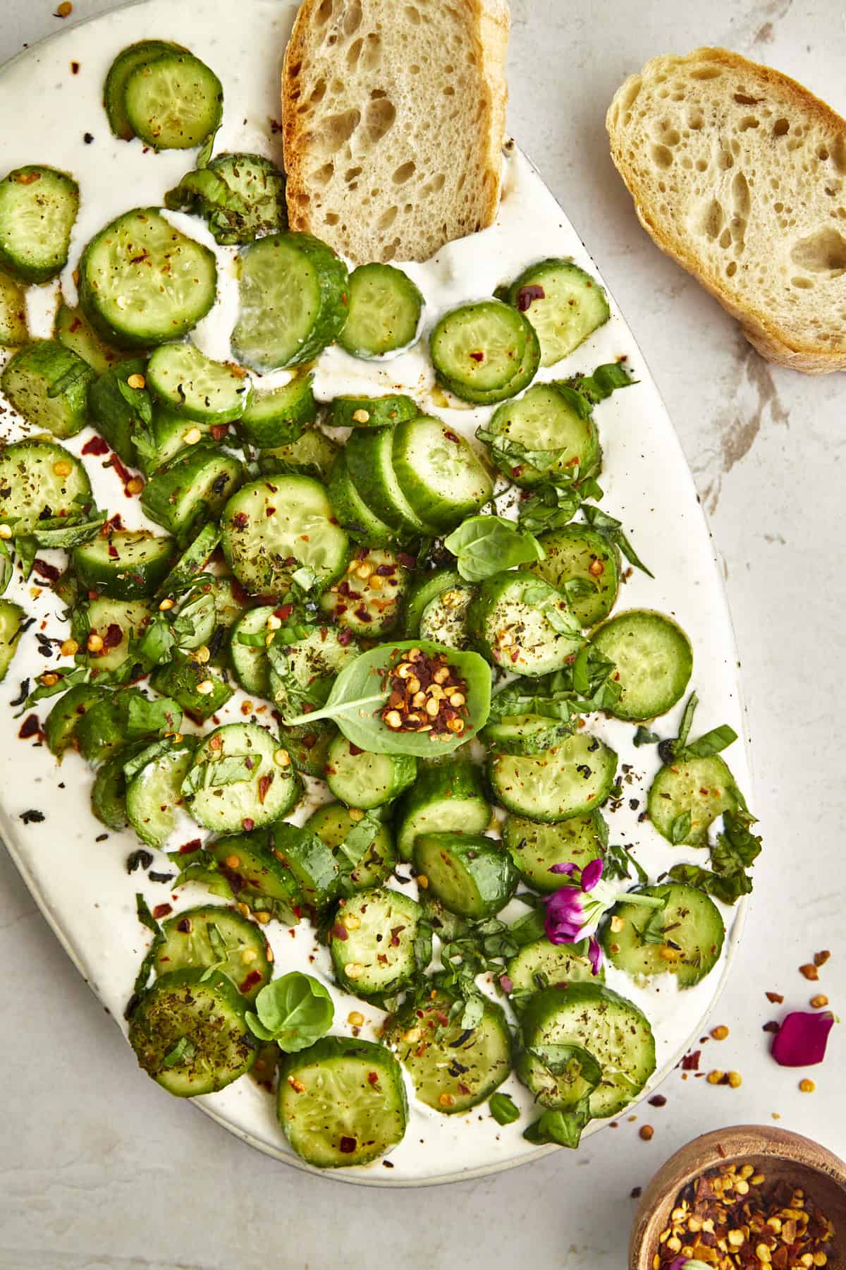 A platter of cucumber cottage cheese dip with two pieces of bread on the side.