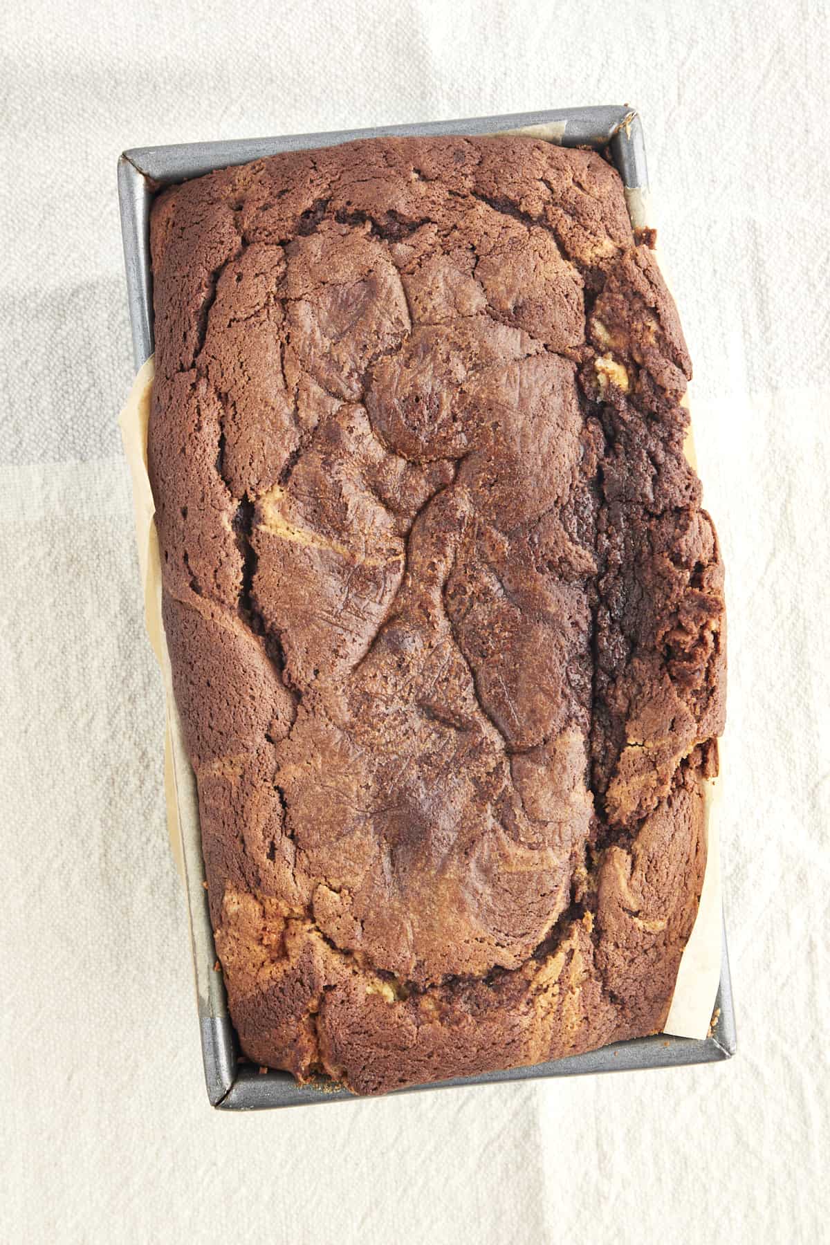 Overhead image of baked marble cake in a loaf pan. 