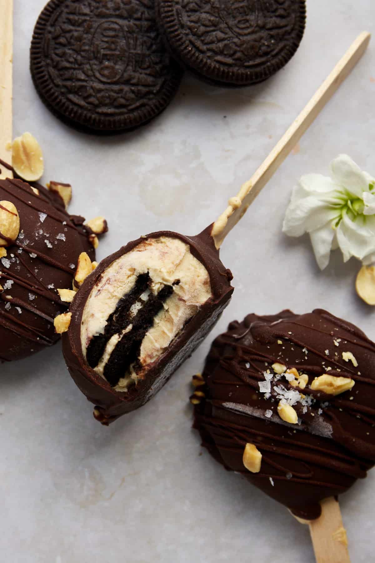 Peanut butter Oreo yogurt popsicles with a bite missing from one. 
