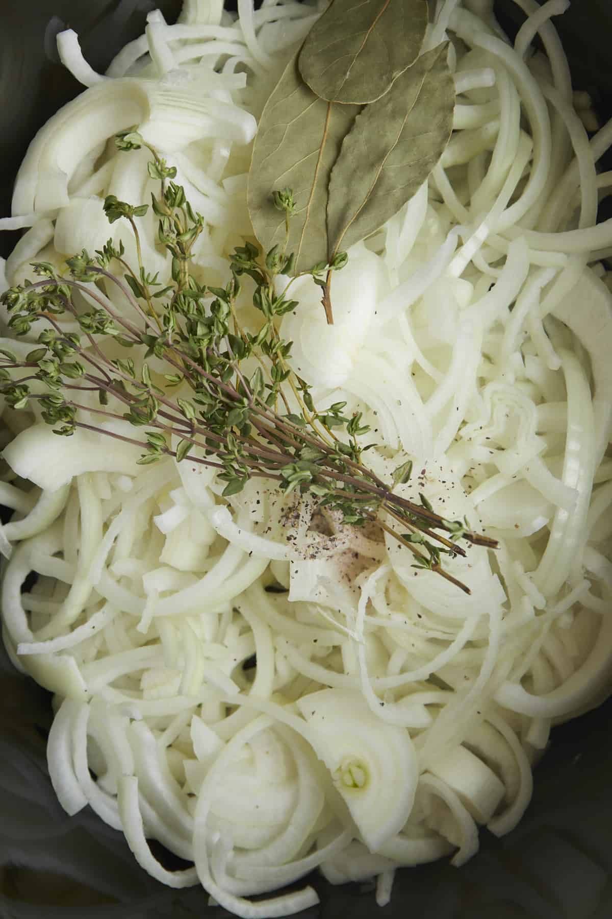 Onions, basil, and parsley in a slow cooker. 