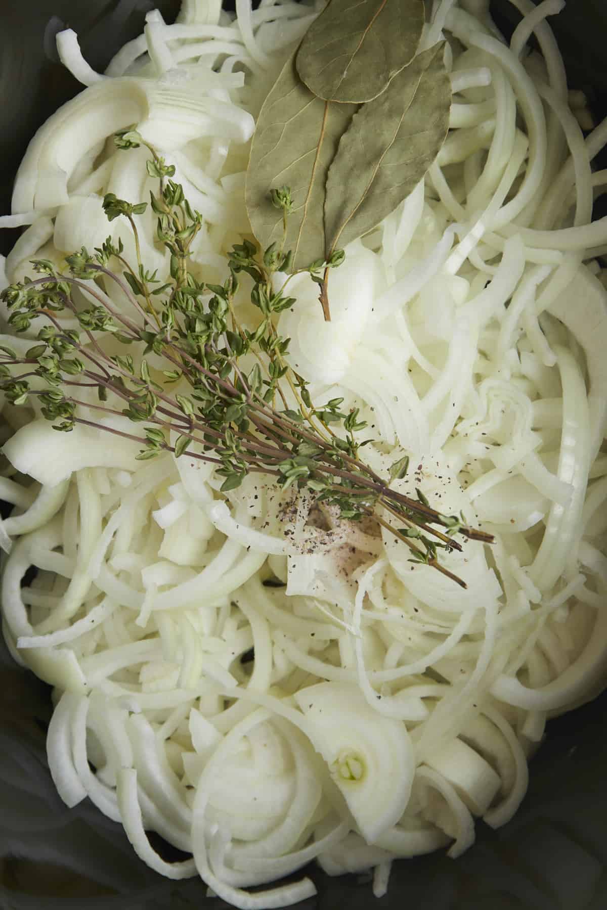 Onions, basil, and parsley in a slow cooker.