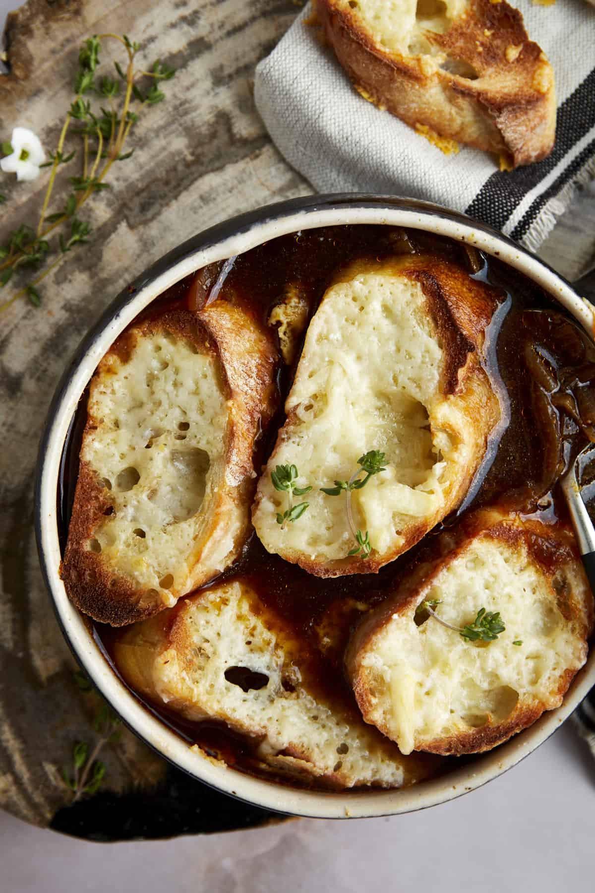Overhead image of a bowl of easy French onion soup topped with toasted bread. 