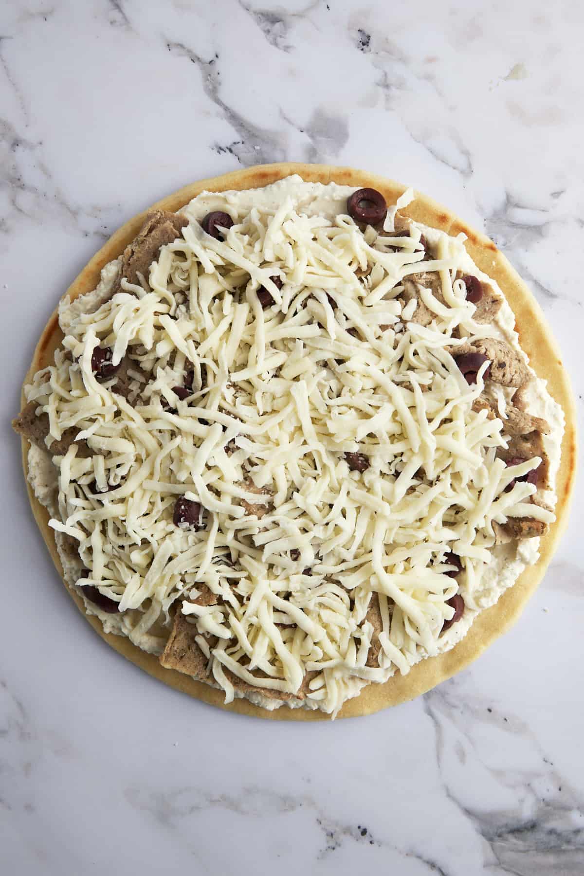 Pizza crust topped with whipped feta, gyro meat, olives, and Mozzarella cheese.
