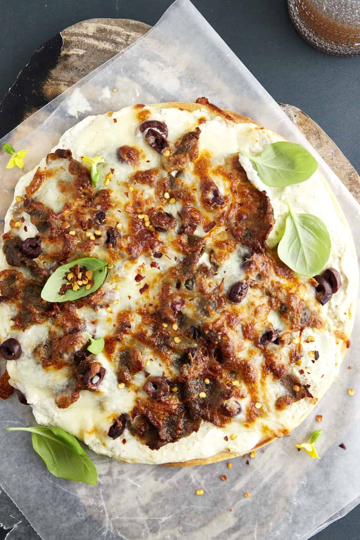 Overhead image of a baked feta gyro pizza topped with red pepper flakes. 