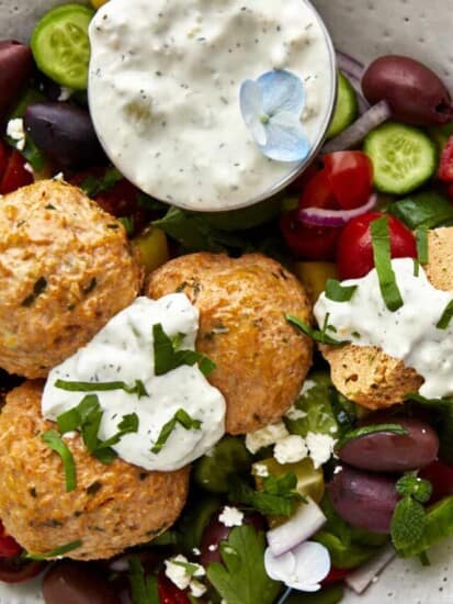 A bowl of chicken shawarma meatballs with veggies and tzatziki.