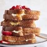 Air fryer french toast sandwiches on a plate topped with berries.