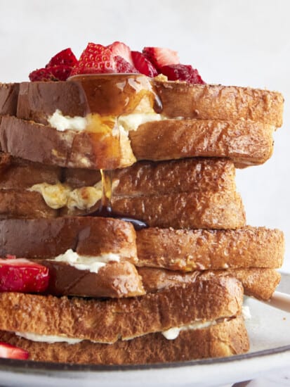 Air fryer french toast sandwiches on a plate topped with berries.
