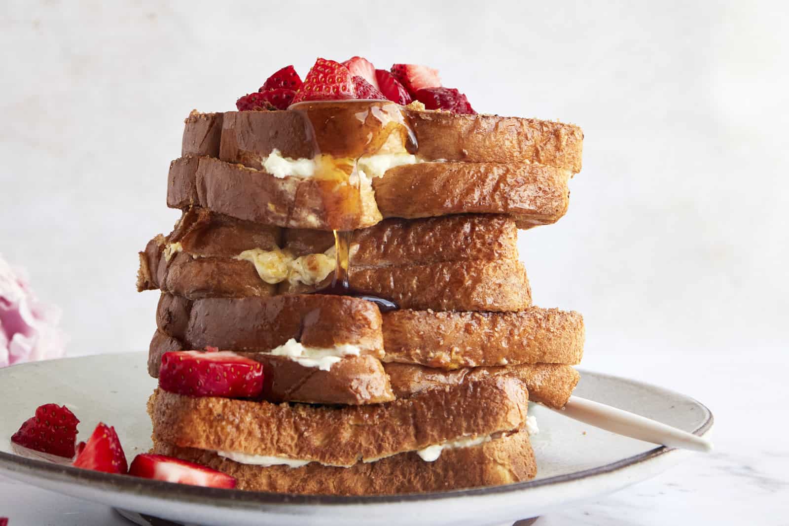 Air fryer french toast sandwiches on a plate topped with berries.
