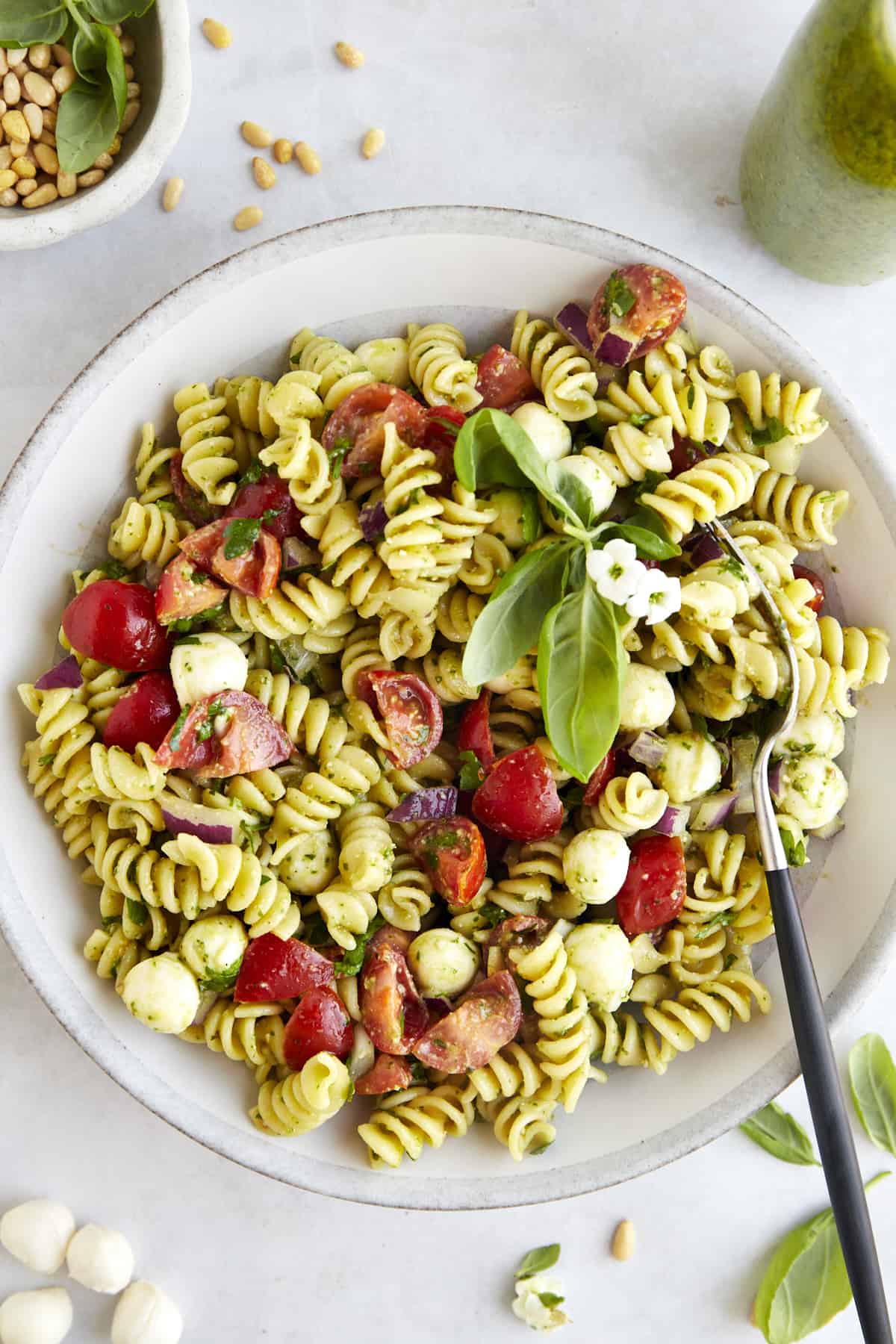 Overhead image of a bowl of pasta salad with pesto with a fork on the side. 