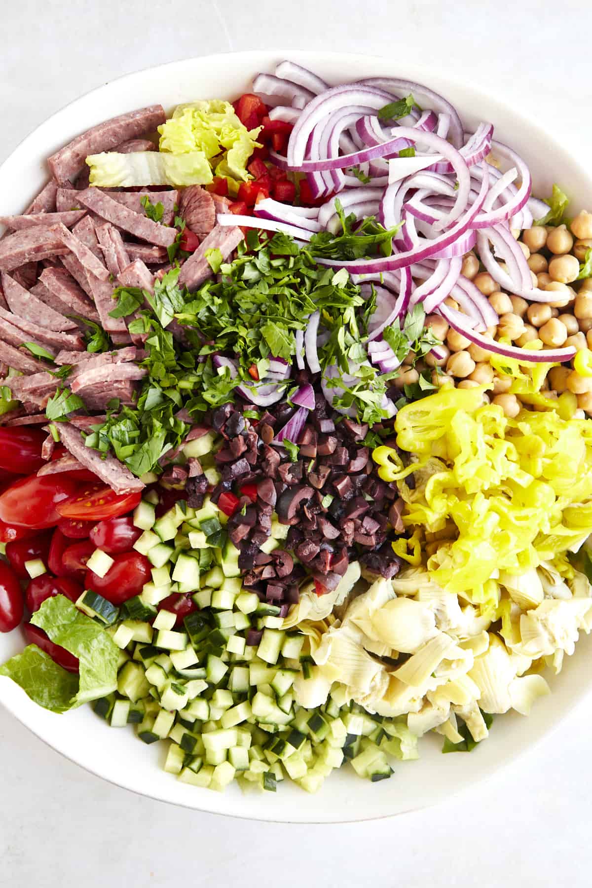 Ingredients for an Italian chopped salad recipe in a bowl waiting to be combined. 