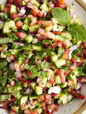 A bowl of Shirazi salad topped with fresh herbs.