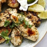 A platter of air fryer lime chicken topped with fresh cilantro.