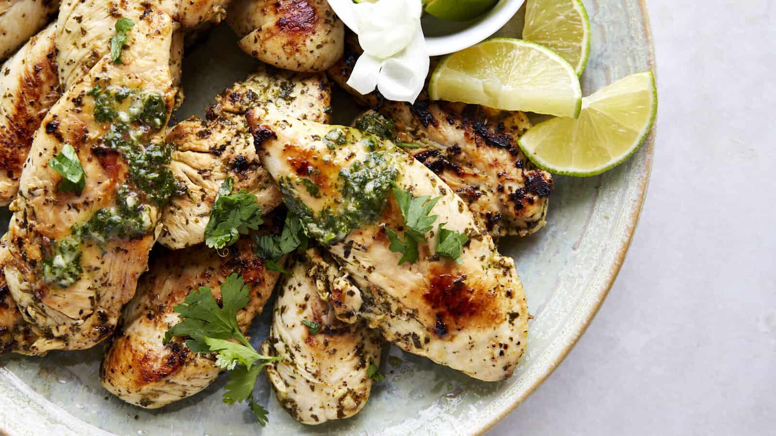 A platter of air fryer lime chicken topped with fresh cilantro.