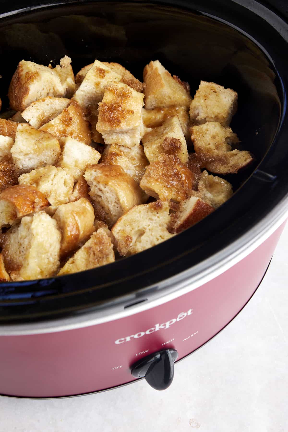 Slow cooker French toast in a crockpot topped with caramelized brown sugar.
