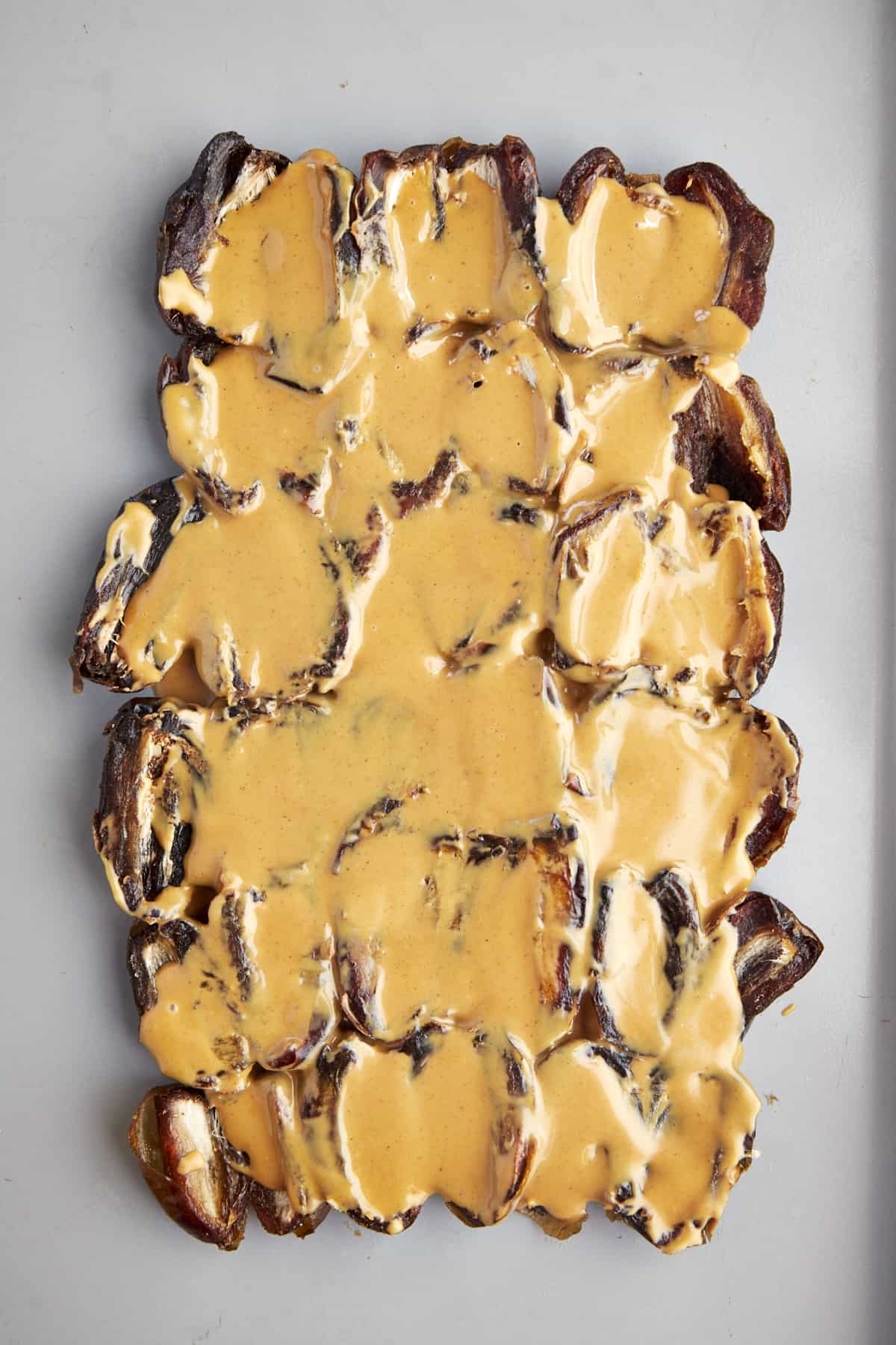 A layer of split dates topped with peanut butter.