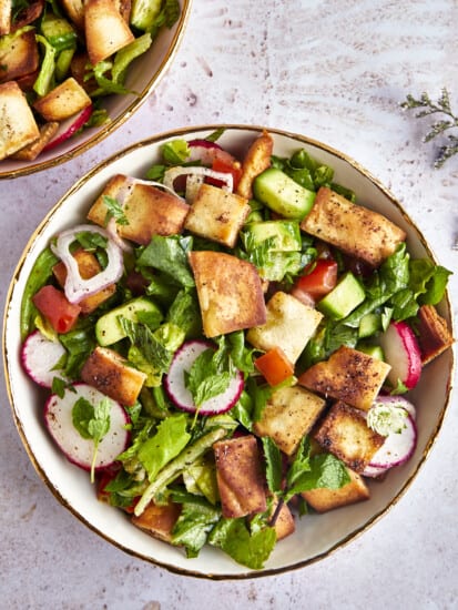 A bowl of fattoush salad topped with pita chips.