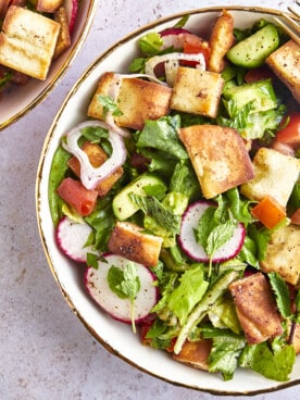 A bowl of fattoush salad topped with pita chips.