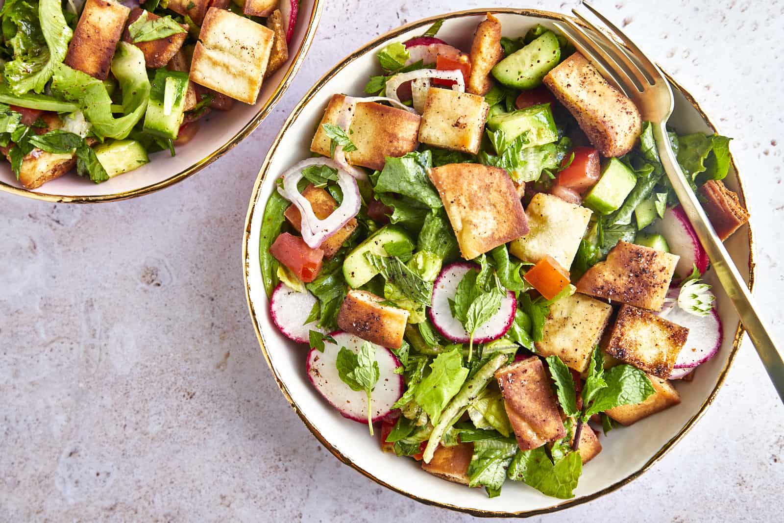 A bowl of fattoush salad topped with pita chips.