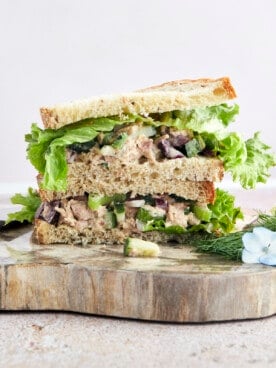 Two halves of a Mediterranean tuna salad sandwich stacked on top of each other.