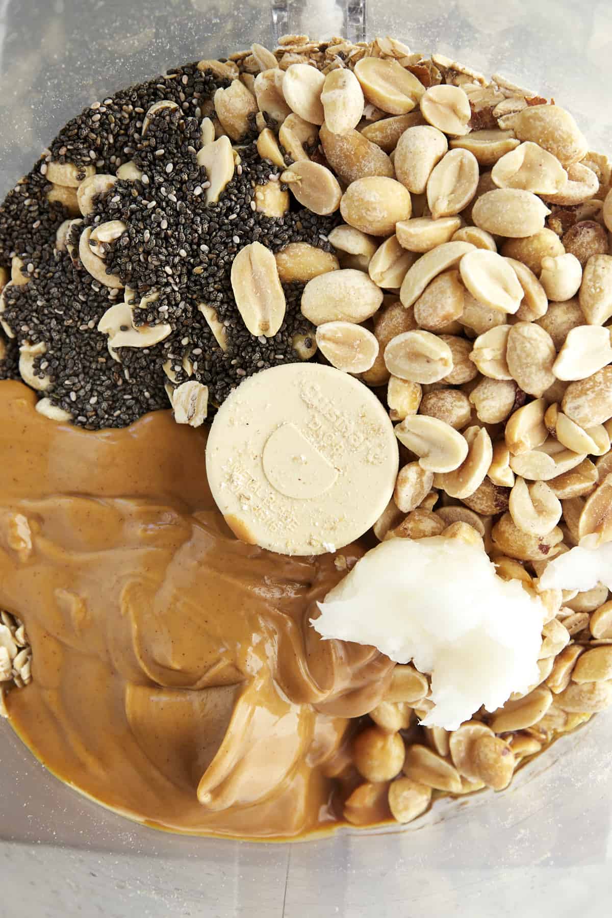 Peanuts, chia seeds, peanut butter, and coconut oil in a food processor.
