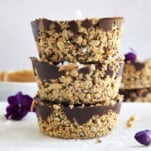 Three no bake peanut butter oat cups stacked on top of each other.