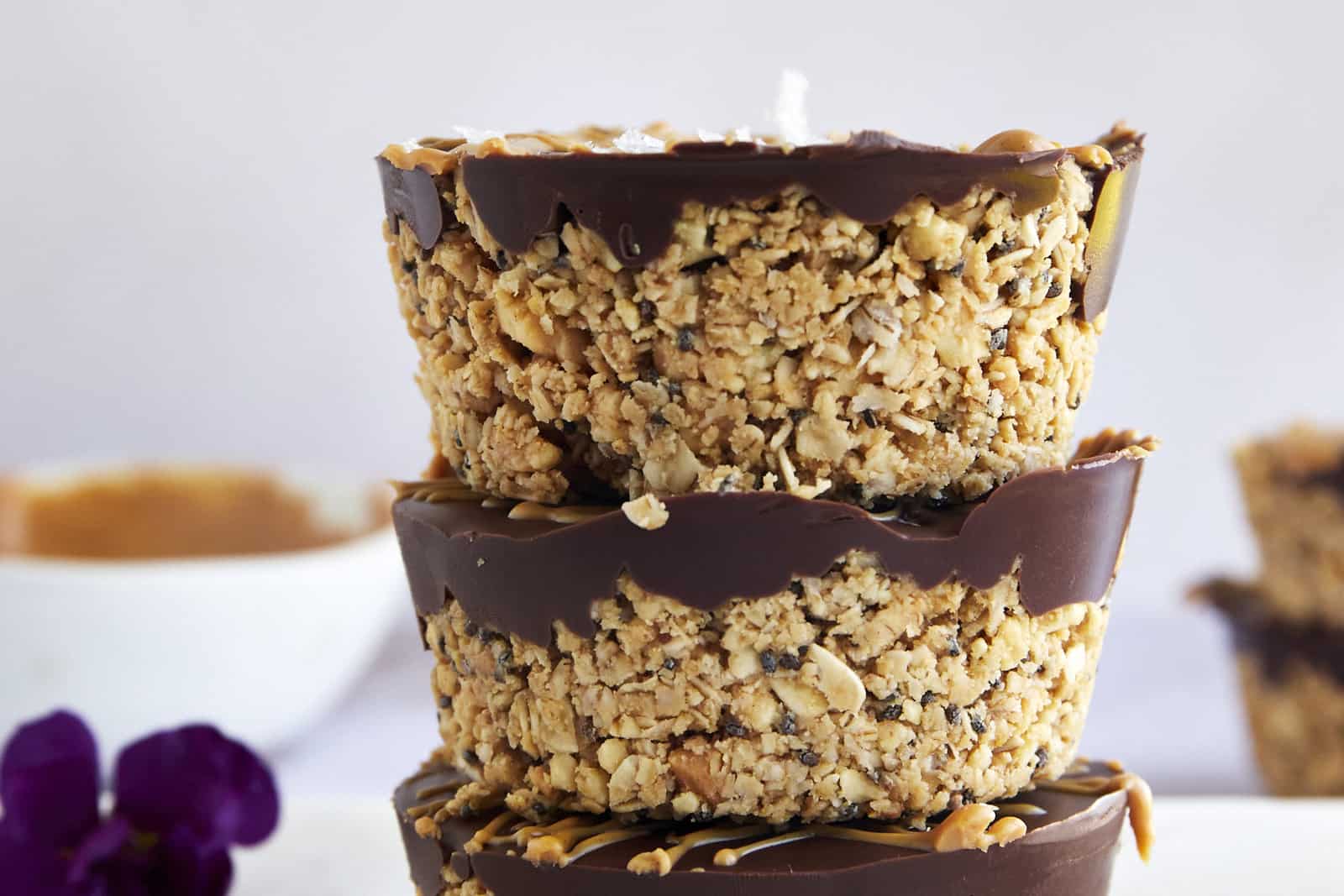 A stack of three no bake peanut butter oat cups on top of each other.