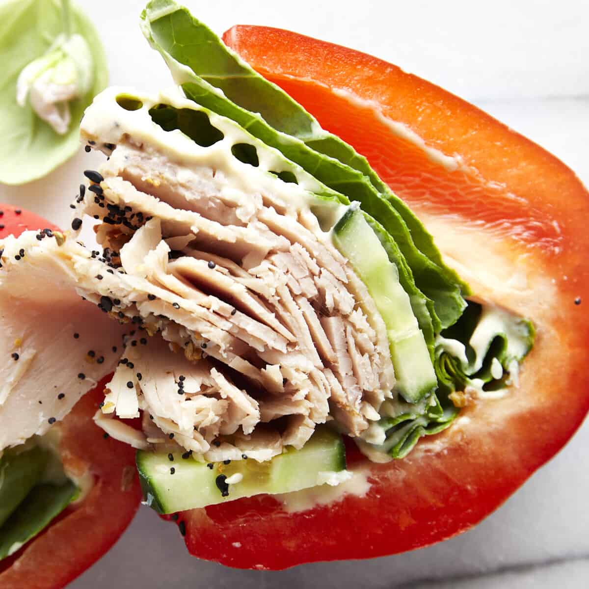 Two halves of a sliced low-carb turkey bell pepper sandwich.